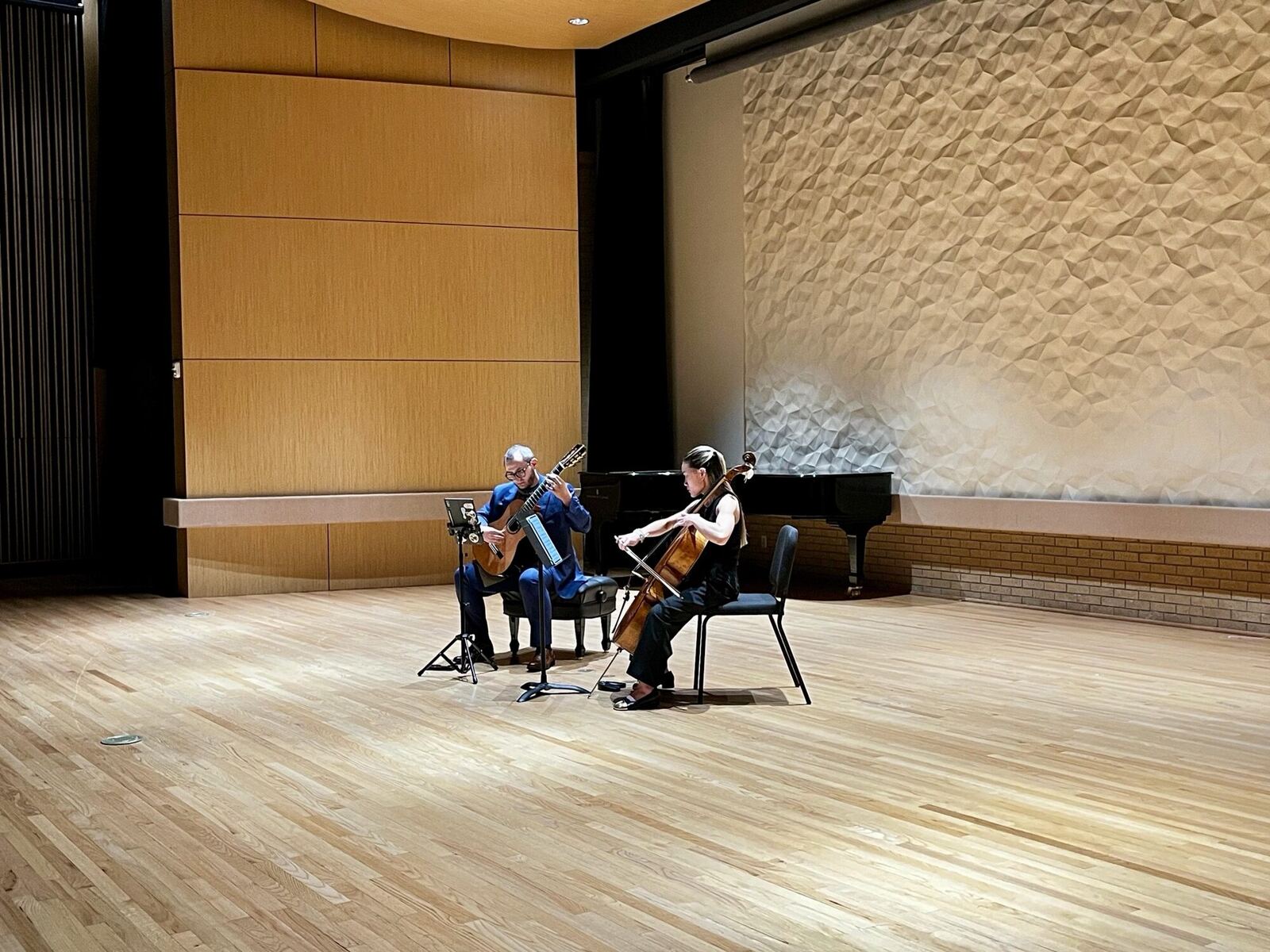 Wide stage view of Andrés Arcila performing a duo with cellist